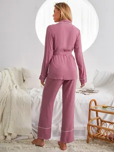 Vista posteriore del set pigiama rosa a maniche lunghe con pantaloni e cintura.