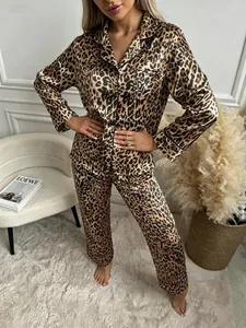Leopard print satin pajama set worn by a model in a stylish indoor home bedroom setting.