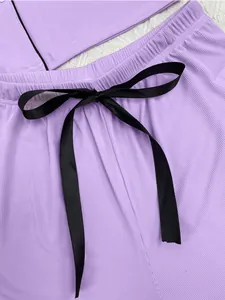 Close-up view of purple ribbed lounge pajama shorts with a black satin bow tie