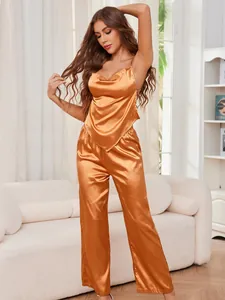 Vista a figura intera di una donna che indossa una canotta in raso oro rame e pantaloni