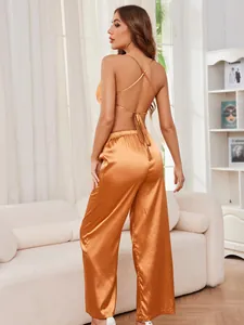 Vista posteriore di un set pigiama in raso arancione con spalline incrociate e pantaloni ampi.
