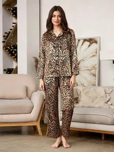 Elegant woman wearing luxury leopard print satin pajama set in a cozy home living room