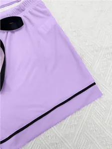 Detail of purple ribbed pajama shorts with black ribbon bow and contrast trim