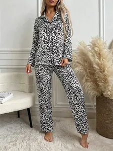 Stylish leopard print pajama set with long sleeves and pants in a cozy home setting.