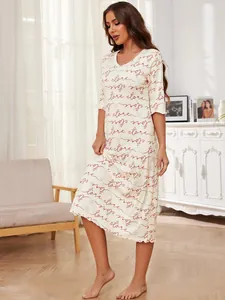 Full view of women's cream nightgown with elegant red script print in home setting