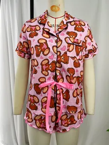 Detailed view of pink cartoon teddy bear print short sleeve pajama set with ribbon
