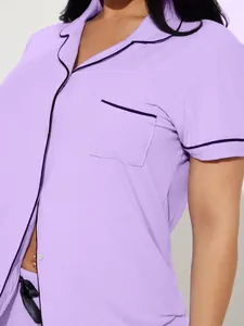 Detail view of purple ribbed pajama top with lapel collar and dark piping detail