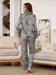 Back view of a women's stylish leopard print satin pajama set in a cozy living room.