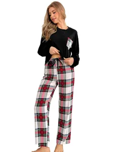 Detail of women's plaid pajama set with black long sleeve top and tartan trousers.