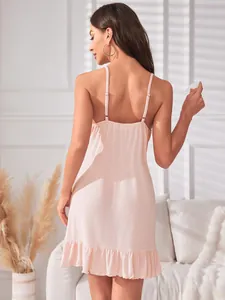 Vue de dos d'une nuisette rose sexy avec fines bretelles et ourlet à volants féminin