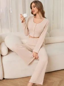Detail of beige ribbed two-piece loungewear set with button-up top and wide-leg pants.