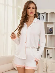 Detail shot of a white modal pajama set with pink trim in a bright home setting
