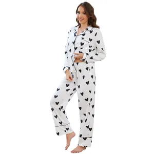 Women's white pajama set with black heart print featuring long sleeves and pants