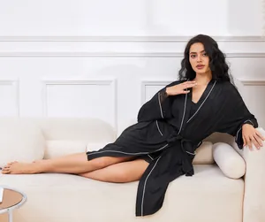 Peignoir et chemise de nuit noirs élégants présentés sur un canapé blanc moderne