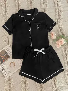 Black short sleeve pajama set with white piping and heart embroidery detail