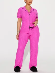 Pink polka dot pajama set featuring a short-sleeve button-down shirt and long pants