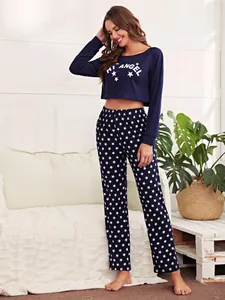 Detail of navy blue pajama set featuring a crop top and star-print pants in a cozy home setting