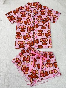 Close-up view of a pink two-piece pajama set featuring cute cartoon bear and heart patterns