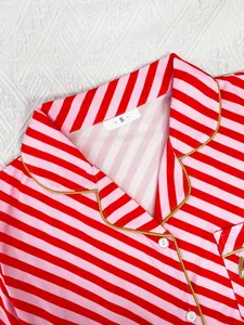 Close-up of red and pink striped pajama top with notched lapel and gold piping detail