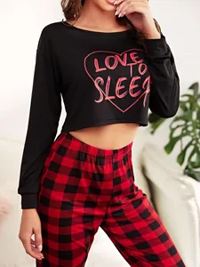 Close-up detail of women's black long sleeve crop top and red buffalo plaid pants set