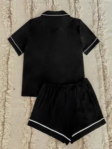 Detailed back view of a black women's pajama set with elegant white piping trim