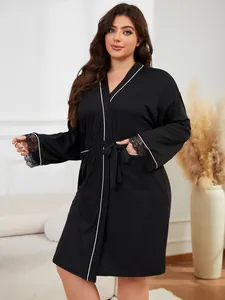 Peignoir noir grande taille élégant avec liseré contrasté blanc et poignets en dentelle.