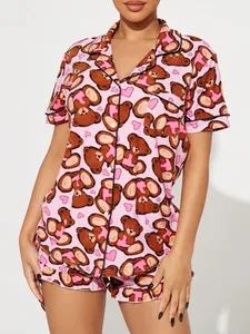 Close-up of pink women's pajama set featuring cute cartoon teddy bear and heart pattern