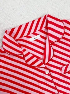 Detail of red and pink striped pajama collar with size M tag on white fabric