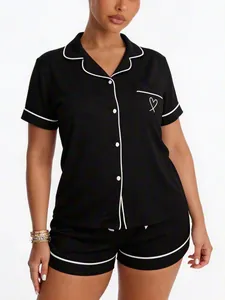 Soft black short-sleeved pajama set with white contrast piping and heart pocket detail