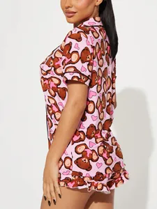 Detail view of a pink pajama set with cute teddy bear and heart print for women.