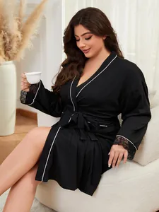 Vue détaillée d'un élégant peignoir noir grande taille avec garniture blanche et dentelle.