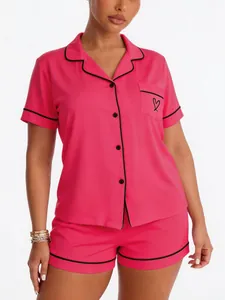 Premium pink short-sleeved pajama set featuring black contrast piping and heart pocket detail