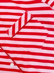 Detailed close-up of red and pink striped fabric on women's pajama pocket with button