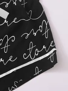 Macro detail of women's black pajama shorts featuring white script cursive print