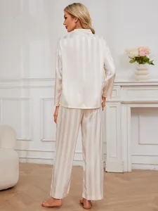 Rear view of women's beige striped satin pajama set in a stylish home setting
