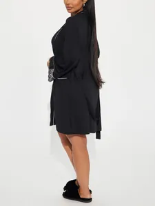 Vue détaillée d'un peignoir en satin noir avec poignets en dentelle et ceinture nouée.