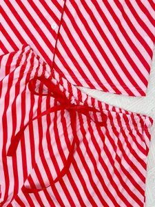 Detail view of red striped pajama shorts featuring a delicate red satin ribbon bow.