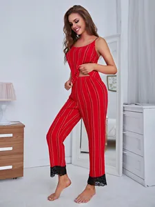 Close-up detail of a red striped two-piece pajama set featuring black lace trim on the pants