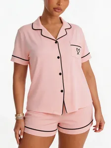 Soft pink women's modal-like pajama set with heart embroidery and black piping trim.