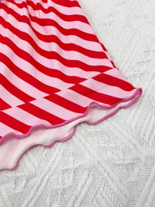 Macro view of red and pink striped pajama shorts with ruffled lettuce edge design