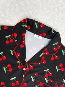 Close-up of cherry print and red piping on black women's pajama collar