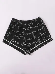 Detailed view of women's black pajama shorts with white cursive love and heart print