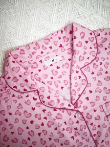 Close-up detail of pink heart print pajama top collar with white size M label