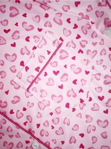 Detailed macro view of pink women's pajamas featuring a cute heart print and pocket