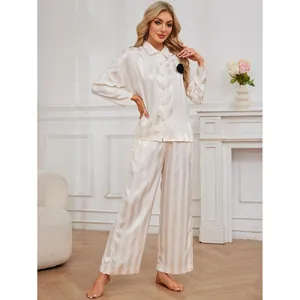 Elegant women's striped satin pajama set with long sleeves and black flower detail.