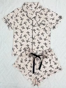 Two-piece women's pajama set with heart bow print, short sleeves and black piping detail.