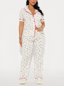 Detail of women's white pajama set featuring cute red cherry print and short sleeves