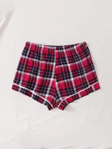 Detailed view of women's summer red and black plaid pajama shorts with white piping accents
