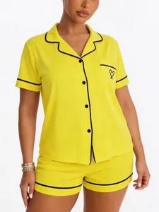 Detailed view of yellow pajama set with black contrast piping and heart pocket detail