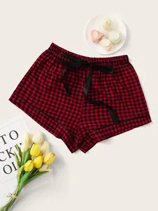Close-up of stylish red and black buffalo plaid pajama shorts with a black ribbon bow.